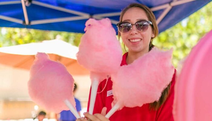 A James Event Productions employee offers you cotton candy with a smile.