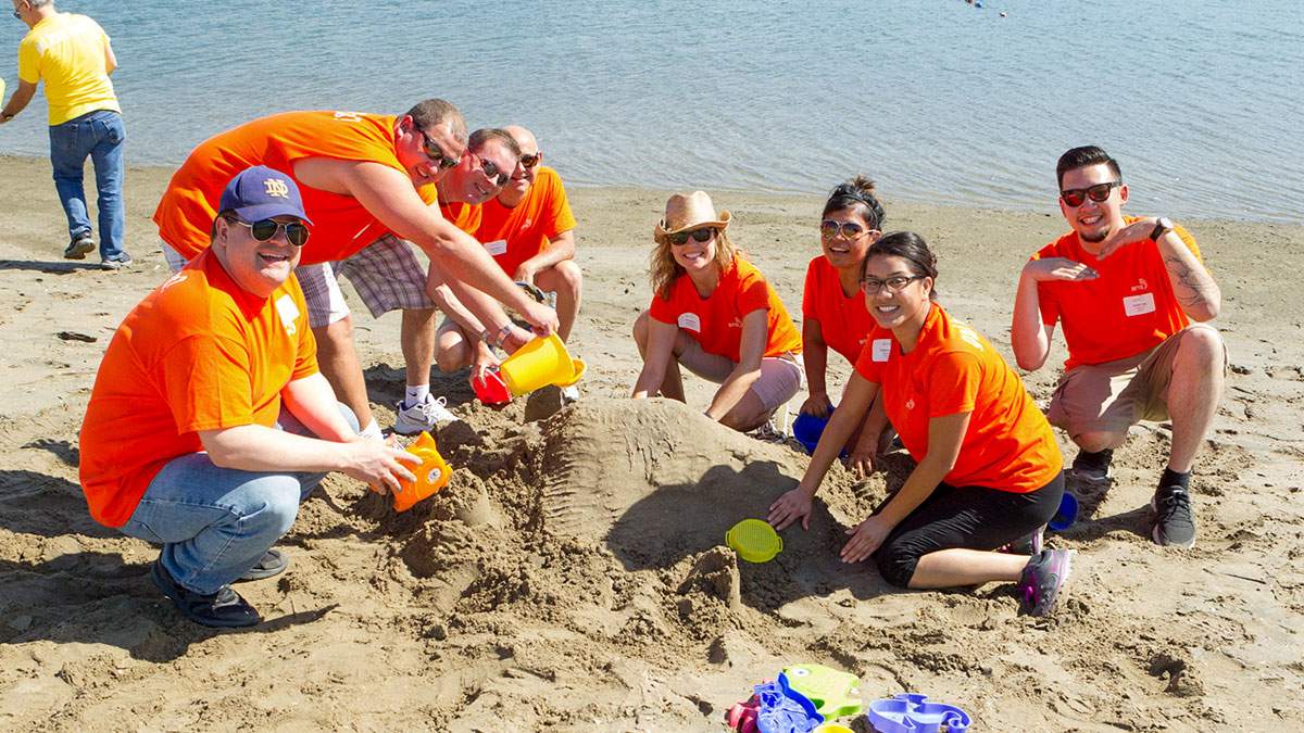 Employees competeing in a sand castle building event during a team building competiton led by James Event Production dirtectors.