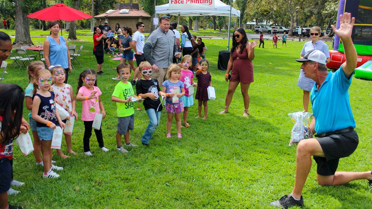 A James Event Productions games director leads a group of children through a set of fun games in Frank G. Bonelli Park during a company picnic.