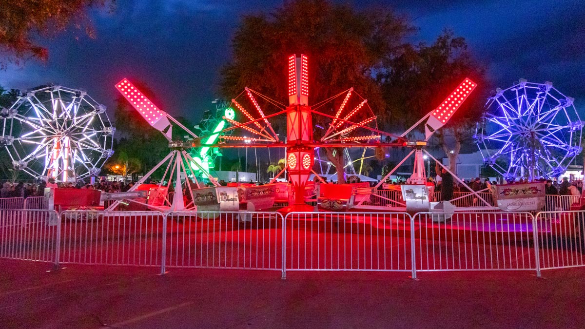 Carnival Rides on the midway lit by colorful neon lights and provided by James Event Productions.